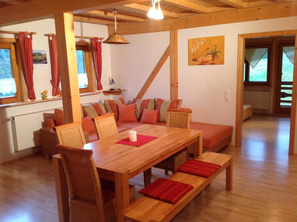a dining room with a table and a couch at Holzbildhauerei Kammerer in Triberg