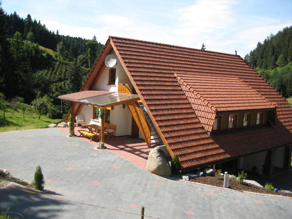 a small house with a brown tile roof at Holzbildhauerei Kammerer in Triberg
