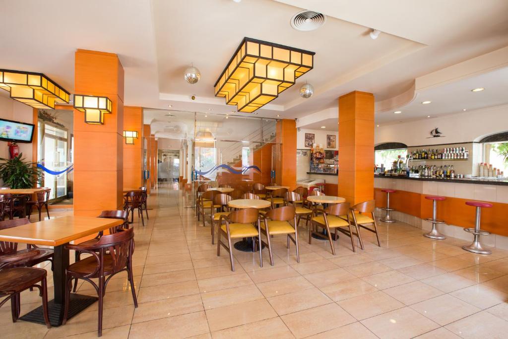 a restaurant with tables and chairs and a bar at Hotel Costa Brava in Blanes