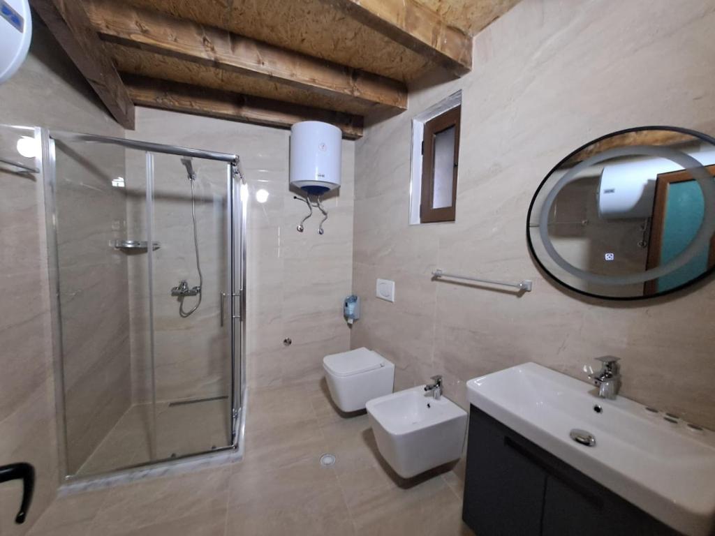 a bathroom with a shower and a toilet and a sink at Hotel Demaj in Berat