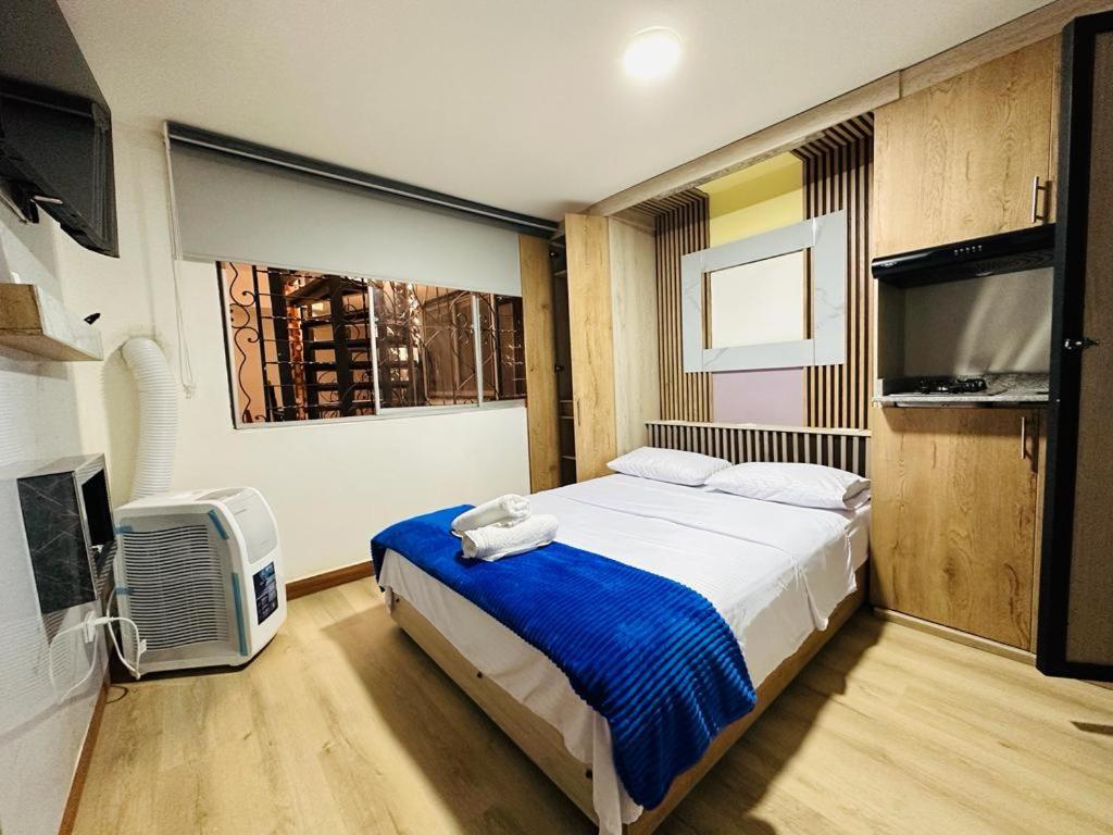 - une chambre avec un lit et une télévision à écran plat dans l'établissement Hotel Lares 70 Laureles, à Medellín