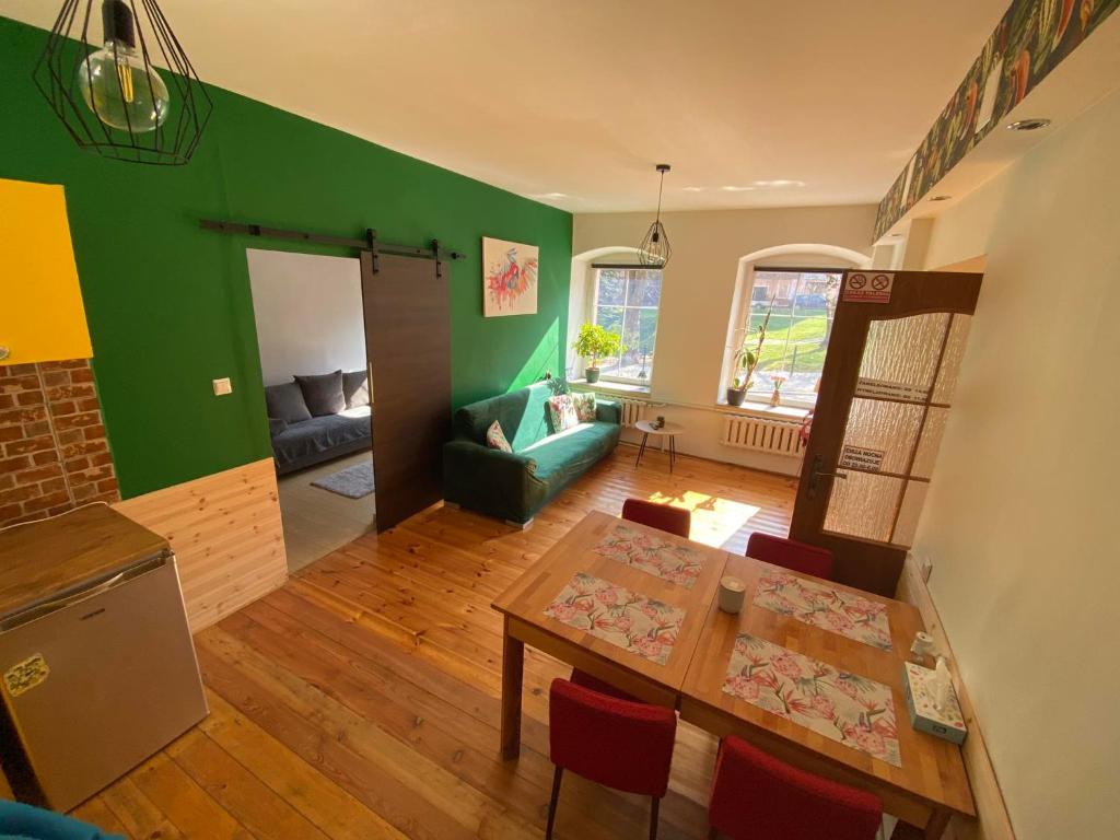 a living room with a table and a green wall at Pod Papugami in Srebrna Góra