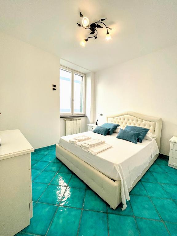 a white bedroom with a bed and a ceiling fan at Putechella's Apartments in Maiori