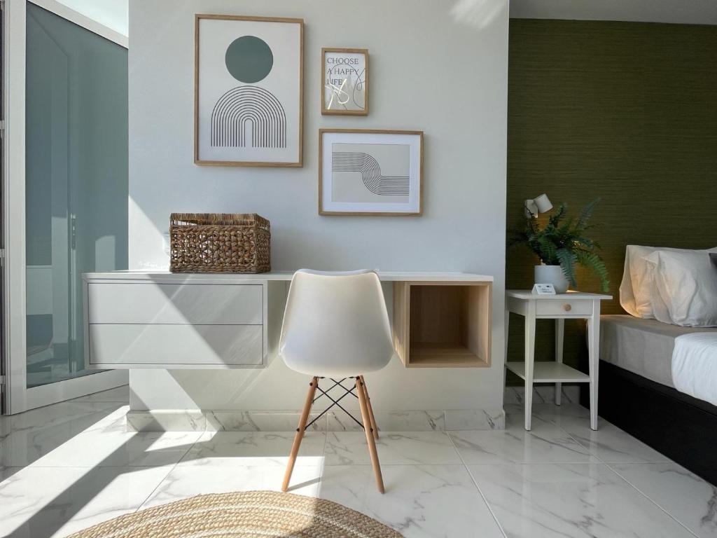 a bedroom with a white chair and a bed at APTO Exelsior, Yumbo, Dunas y Playa in San Bartolomé de Tirajana