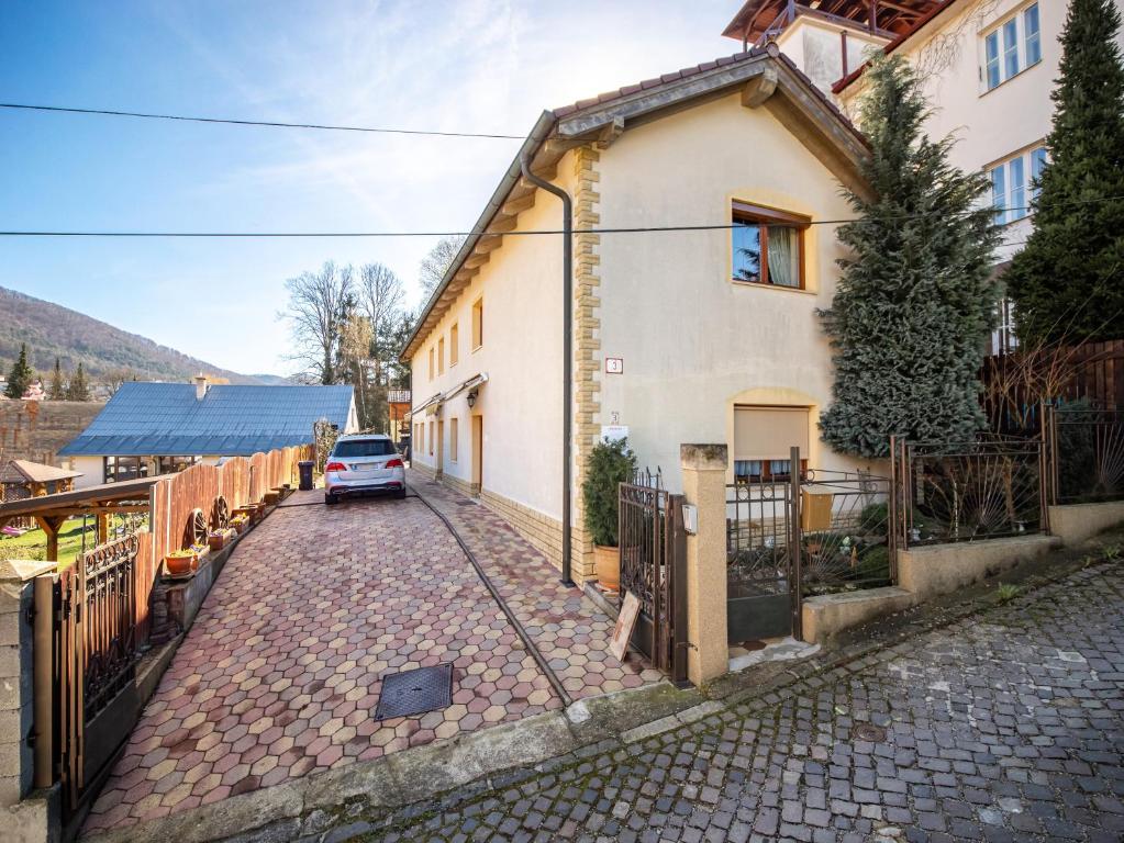 uma casa com um carro estacionado ao lado de uma rua em Ubytovanie Clematis em Trencianske Teplice