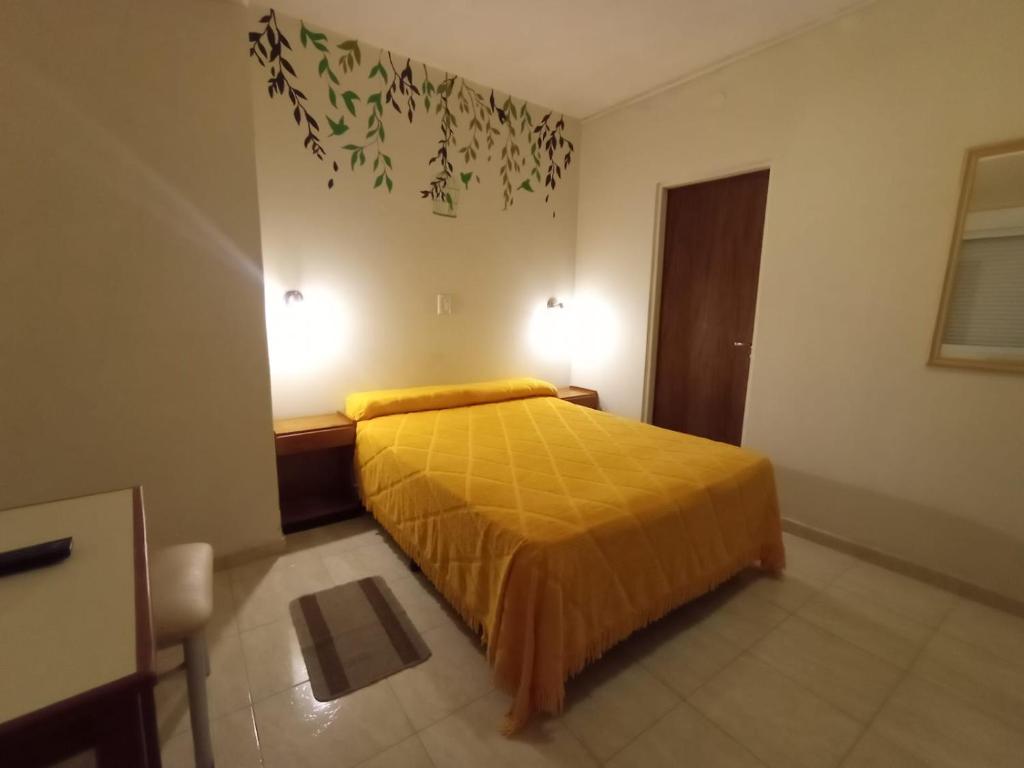 ein Schlafzimmer mit einem Bett und zwei Lampen an der Wand in der Unterkunft HOTEL INTI YACU in Termas de Río Hondo