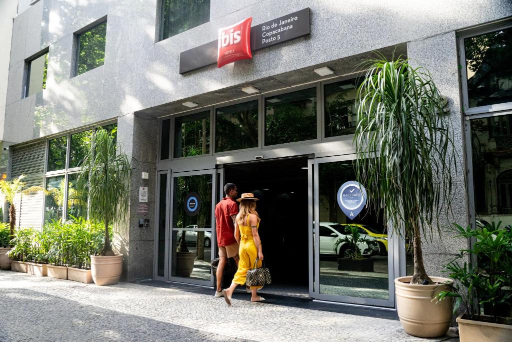 a man and a woman walking out of a store at ibis Copacabana Posto 5 in Rio de Janeiro