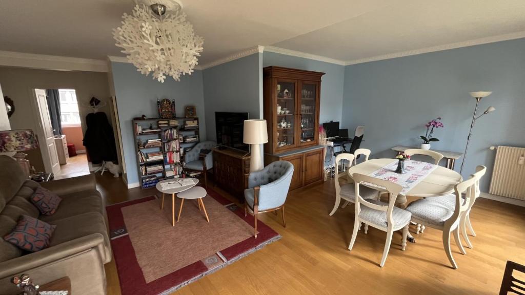 un salon avec une table, des chaises et un canapé dans l'établissement Appartement Boulogne-Billancourt nord Roland Garros, à Boulogne-Billancourt