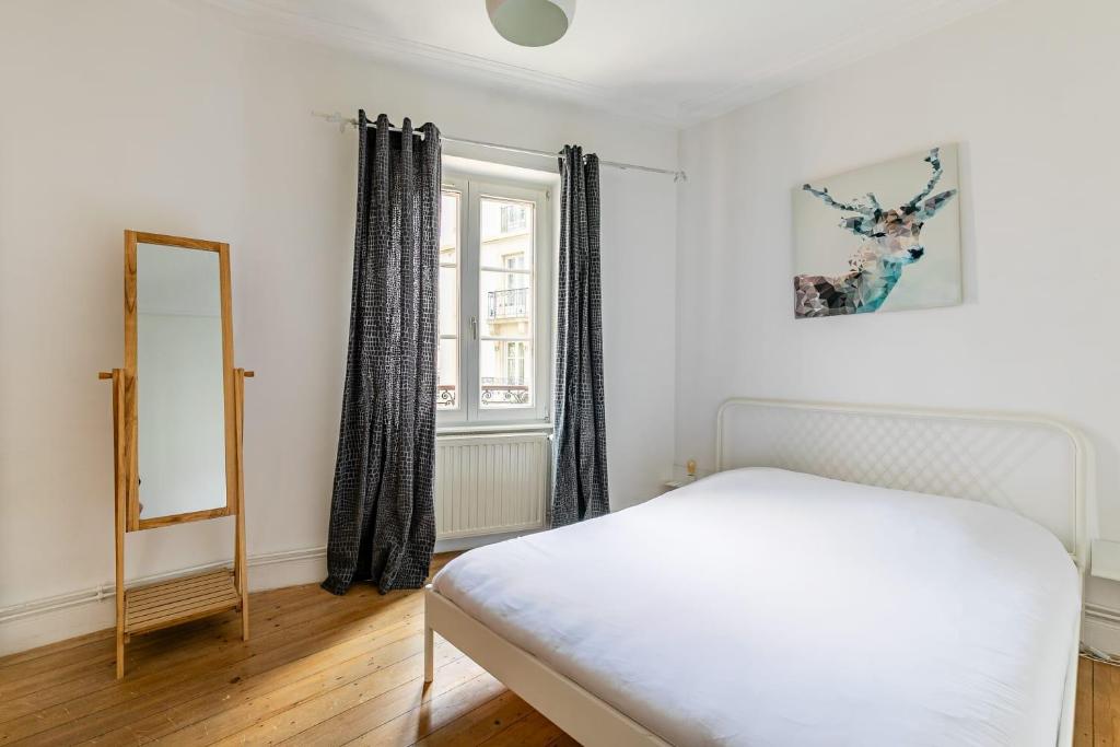 a bedroom with a white bed and a mirror at Appartement 2 chambres avec garage à strasbourg in Strasbourg