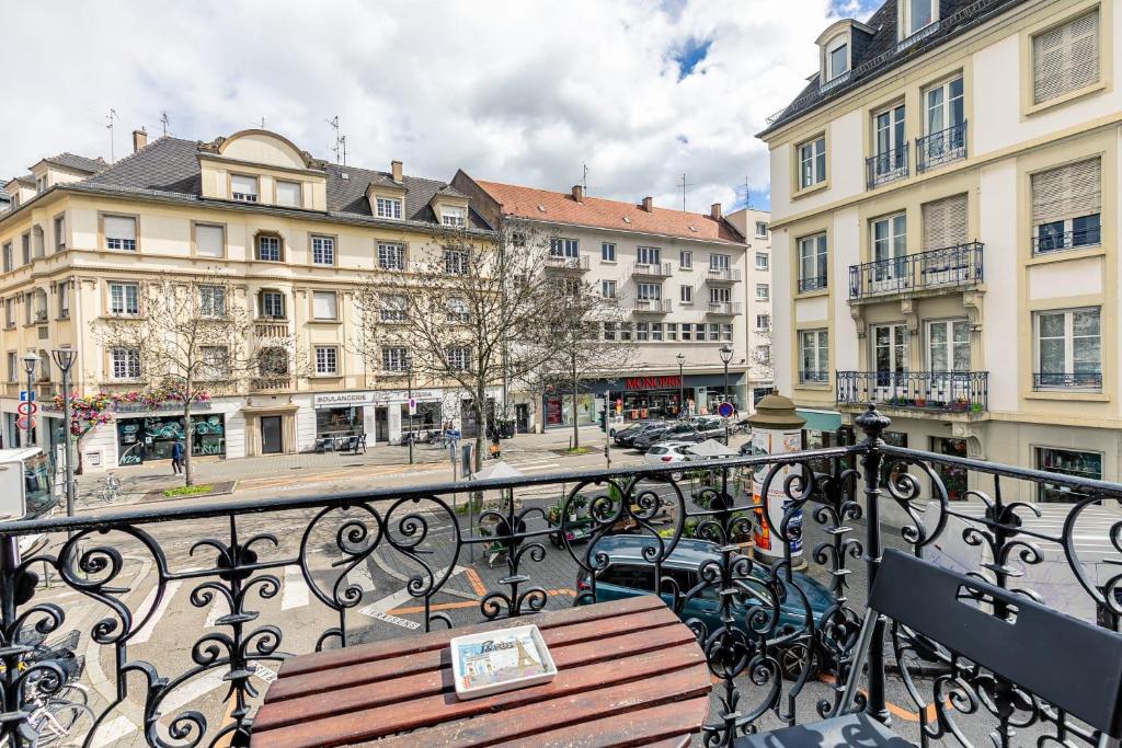 a wooden bench on a balcony with buildings at Appartement 2 chambres avec garage à strasbourg in Strasbourg