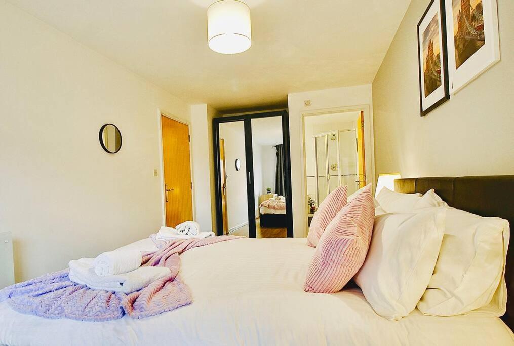 - une chambre avec un lit doté d'oreillers roses et blancs dans l'établissement Long stays Flat in Reading, à Reading