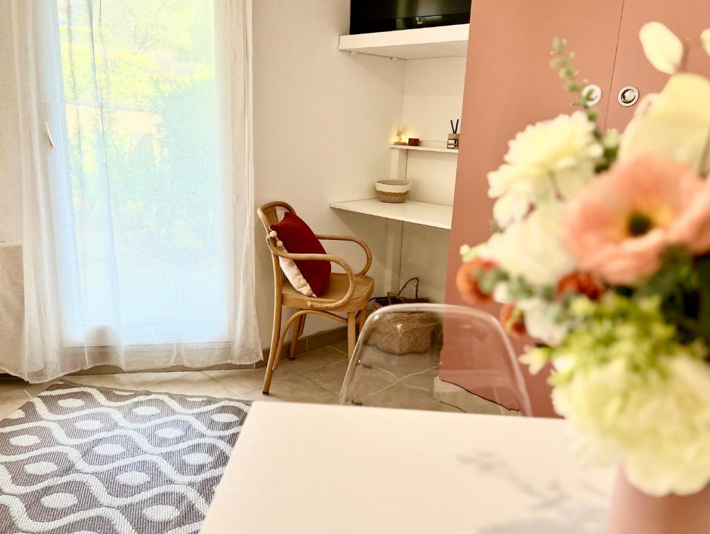 une pièce avec une table, des chaises et une fenêtre dans l'établissement Le Cocon, à Gréoux-les-Bains