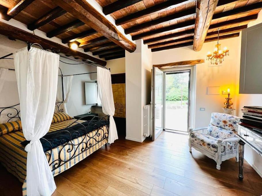 a bedroom with a bed and a chair in a room at La Piccola Fattoria nella Campagna Umbra in Badiola