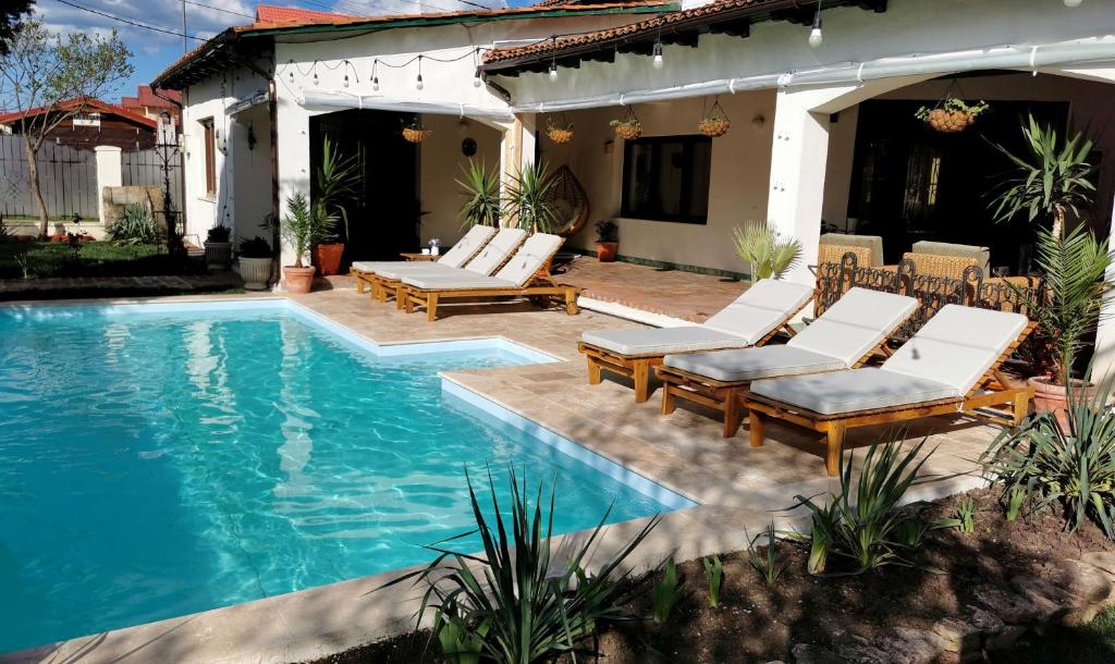 a swimming pool with lounge chairs next to a house at Casa Olive Costinești in Costinesti