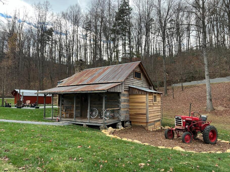 une petite cabine avec un tracteur rouge devant elle dans l'établissement Bear Necessities, à Sevierville