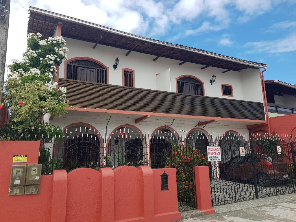 una casa con una recinzione rossa davanti di APART STUDIOS PONTAL a Ilhéus