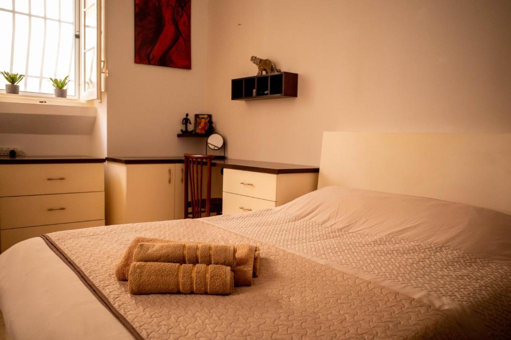 una camera da letto con un letto con due asciugamani sopra di Blue Door Valletta a La Valletta
