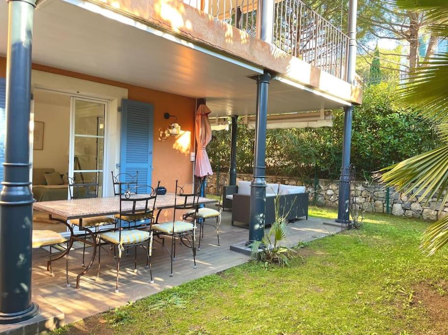 um deque com uma mesa e cadeiras numa casa em Appartement de standing avec jardin em La Croix-Valmer