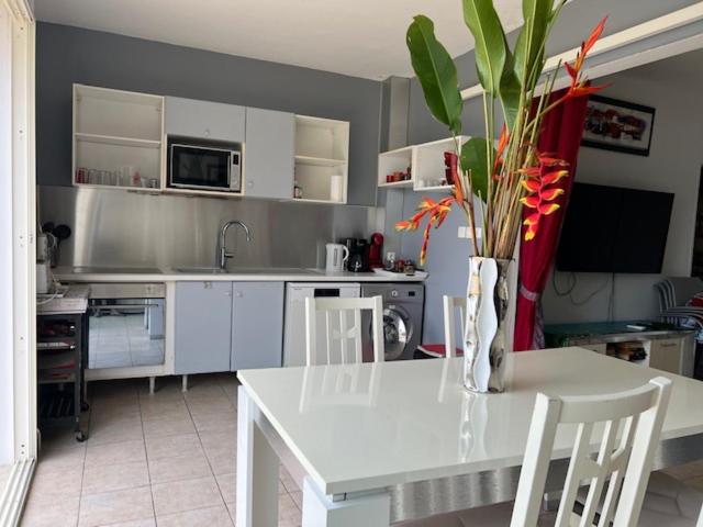 a kitchen with a white table with a vase on it at LE REV&#39;ANOU in Sèze