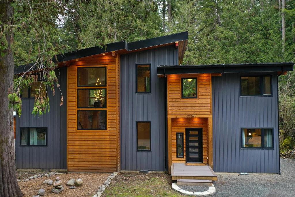 a house in the woods with a black roof at Aspire in Glacier
