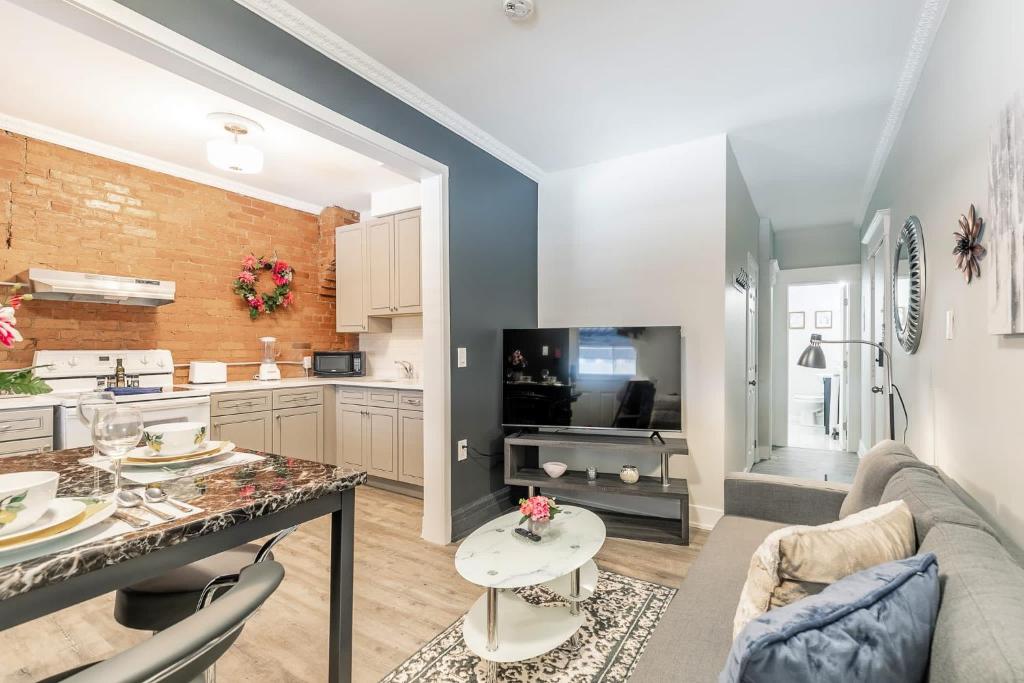 Il dispose d'une cuisine et d'un salon avec un canapé et une table. dans l'établissement James St Apartment Unit - Sleeps 6, à Hamilton