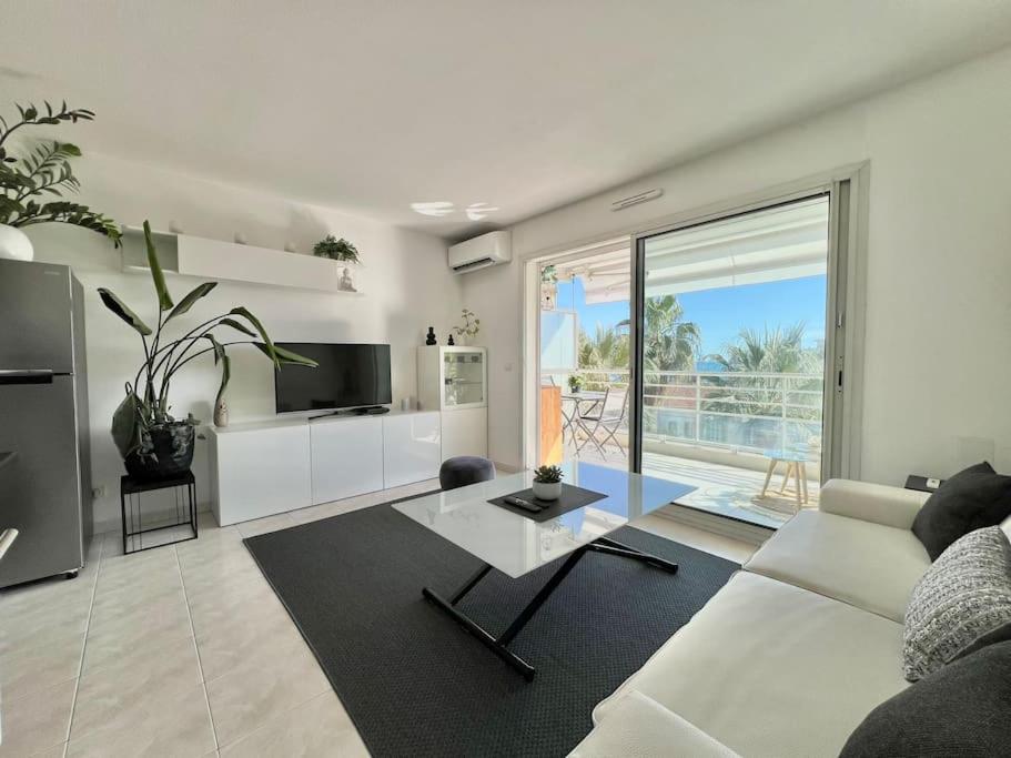 un salon avec un canapé blanc et une table dans l'établissement Studio 3 étoiles vue mer - terrasse - plage, à Vallauris