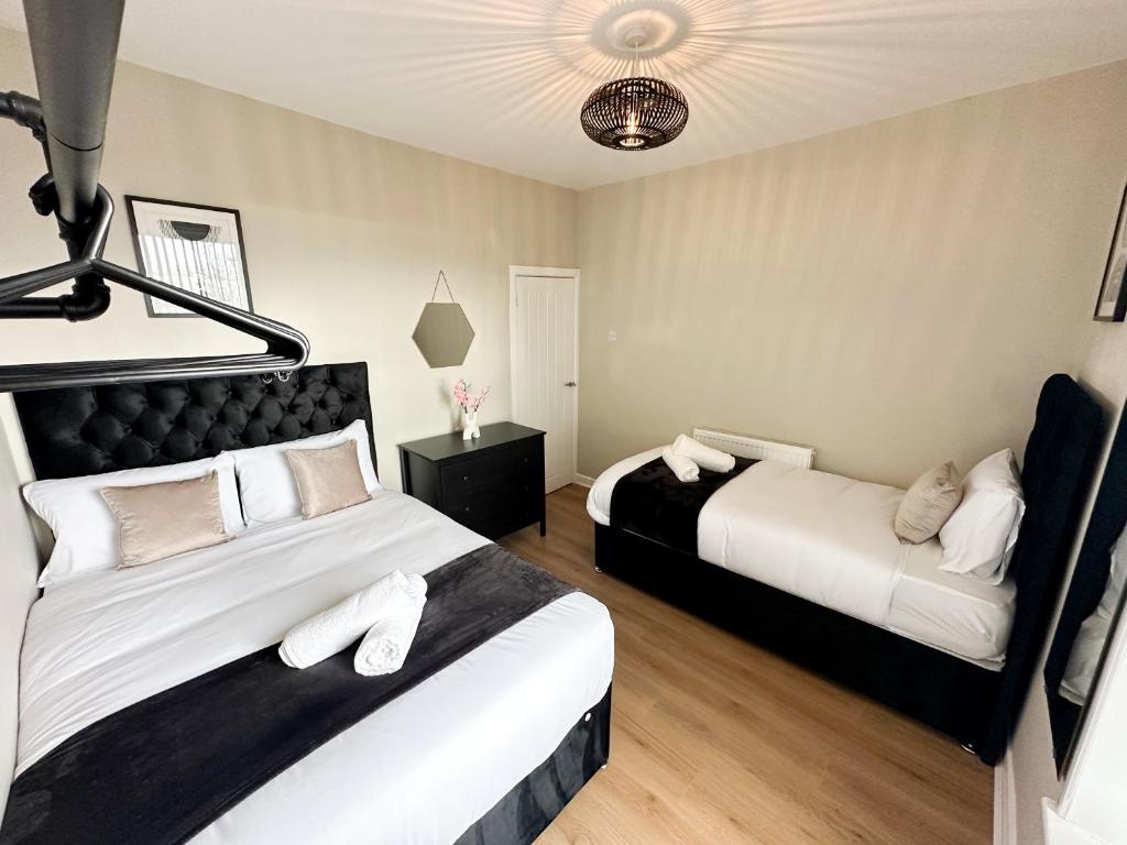 um quarto com 2 camas e almofadas brancas em Brand New Modern Boutique Home em Liverpool