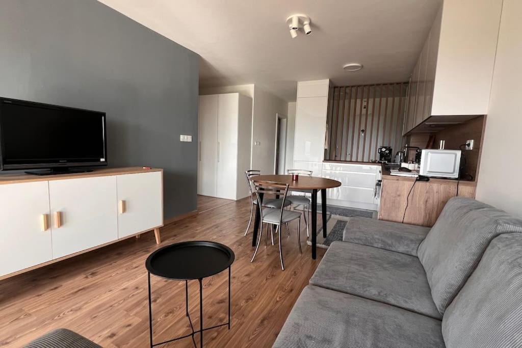 sala de estar con sofá y mesa con sillas en 2 room Apartment, terrace, new building Moruše en Prievoz