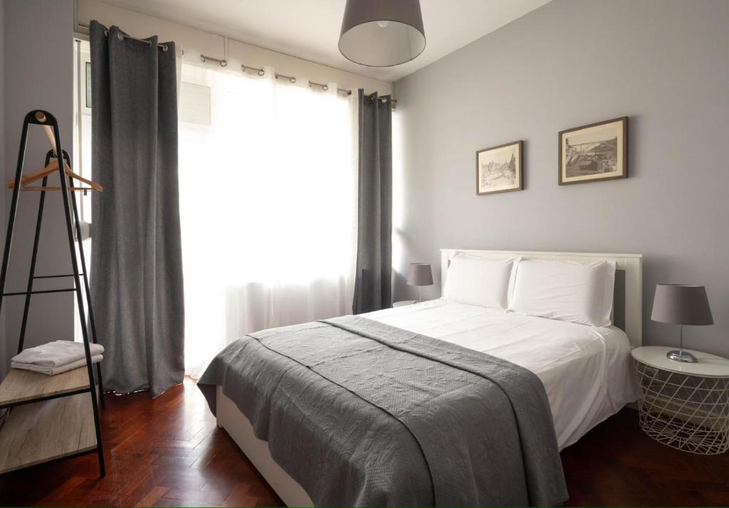 een slaapkamer met een bed, een ladder en een raam bij Lolla's City House in Porto