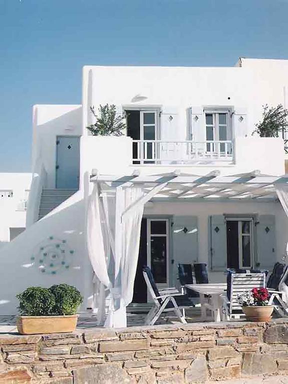a white house with chairs and a table in front of it at Dolce Vita Waterfront Villa, Logaras, Paros in Kampos Paros