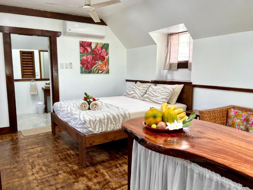 um quarto com uma cama e uma tigela de fruta numa mesa em Tai'inu Bungalows em Amuri