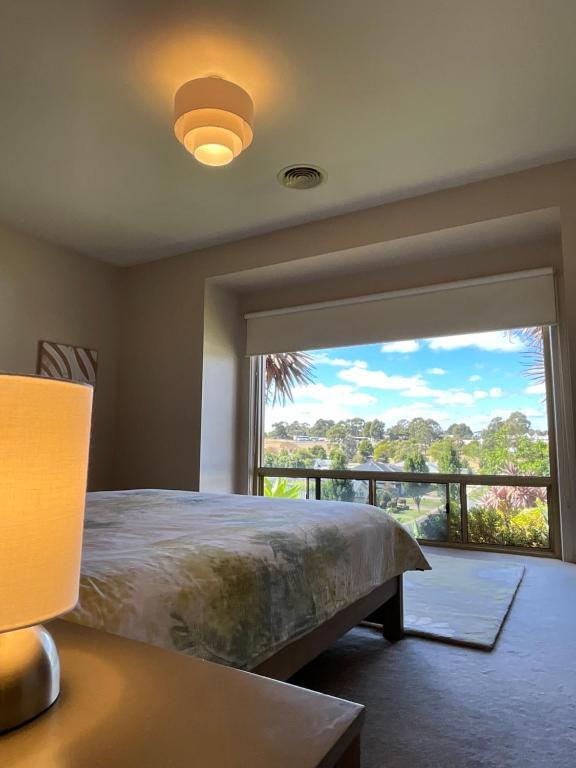 ein Schlafzimmer mit einem Bett und einem großen Fenster in der Unterkunft A Scent of Lavender in Mount Gambier