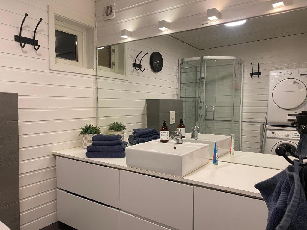 a white bathroom with a sink and a mirror at På toppen av Tromsøya. Rett ut i naturen! in Tromsø