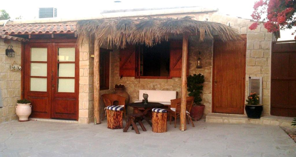 una casa con una mesa y sillas frente a ella en Simona Stone House, en Polis Chrysochous