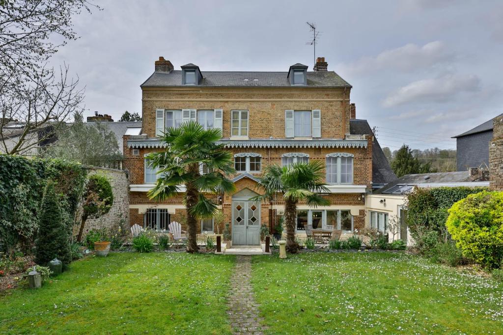 una gran casa de ladrillo con palmeras en el patio en Villa Jane'Laur Magnificent mansion with garden 11 P en Honfleur
