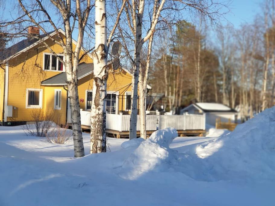 a yellow house with a yard covered in snow at Bergsgatan 5 Arjeplog in Arjeplog