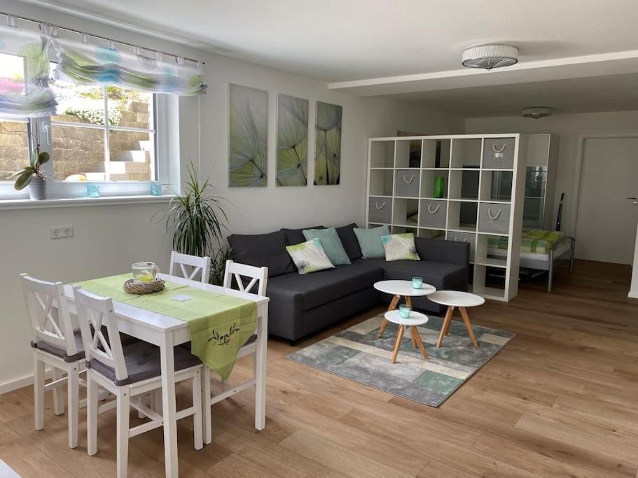 ein Wohnzimmer mit einer Couch und einem Tisch und Stühlen in der Unterkunft Wohnstudio für bis zu 1-4 Personen nahe Bodensee in Stockach