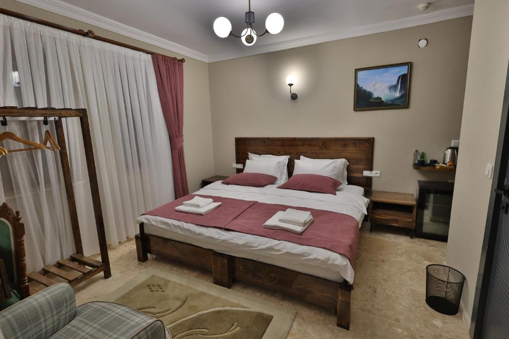 a bedroom with a large bed with two towels on it at Yellow Stone House in Goreme