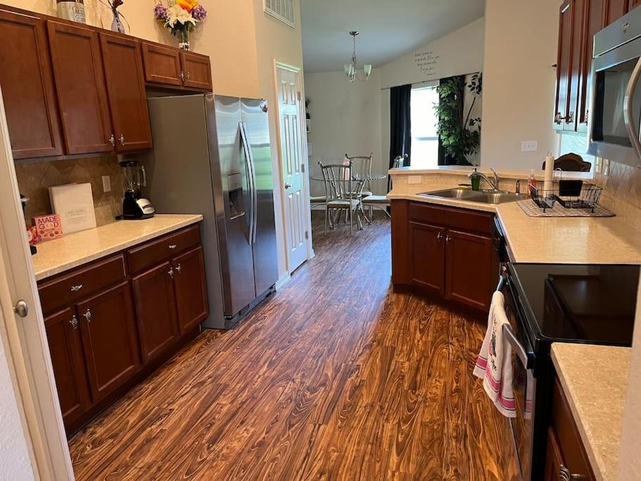cocina con suelo de madera y cocina con electrodomésticos de acero inoxidable en Vacation home near Tampa & Orlando, en Bartow
