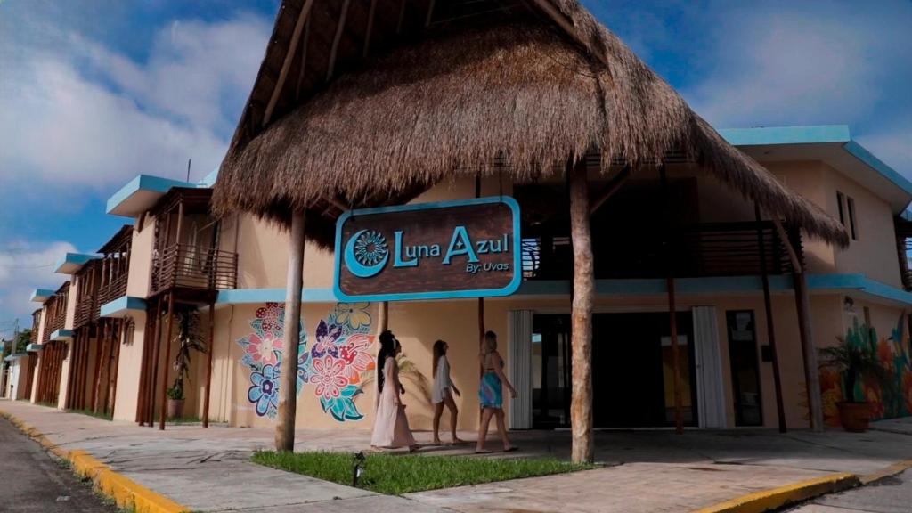 un groupe de personnes debout à l'extérieur d'un bâtiment dans l'établissement LUNA AZUL BY UVAS, à Cozumel