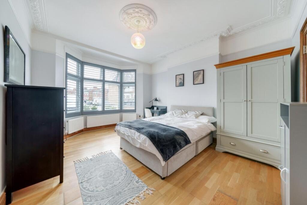 a bedroom with a bed and a large window at London City Large Two Bedroom Apartment in London