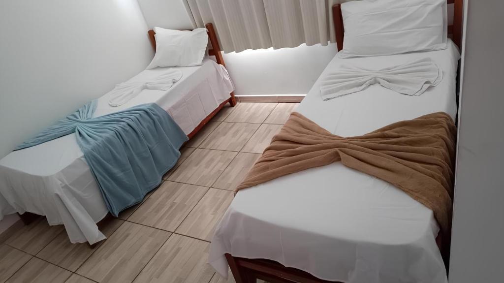 duas camas sentadas uma ao lado da outra num quarto em POUSADA BRASÃO em Governador Valadares