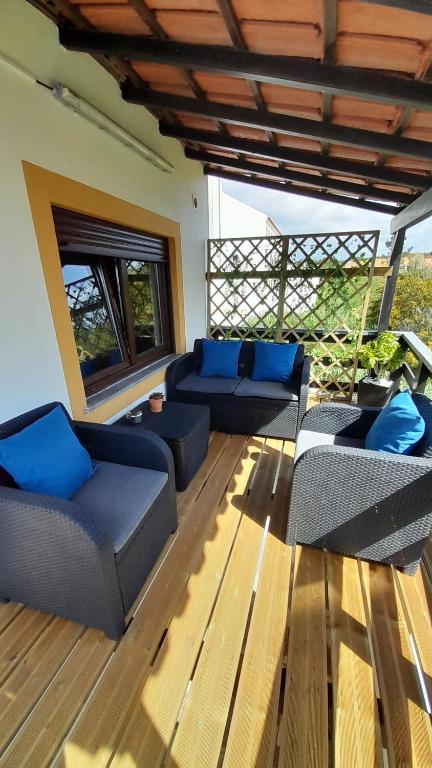 - un salon avec des canapés et des oreillers bleus dans l'établissement Na Rota - Casa de Praia, à Zambujeira do Mar