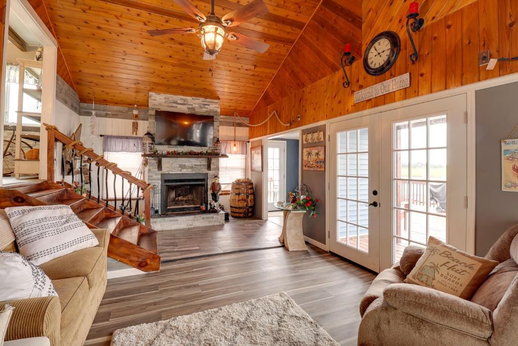 a living room with wooden ceilings and a fireplace at Oceanfront Milford Home with View and Boat Access in Milford