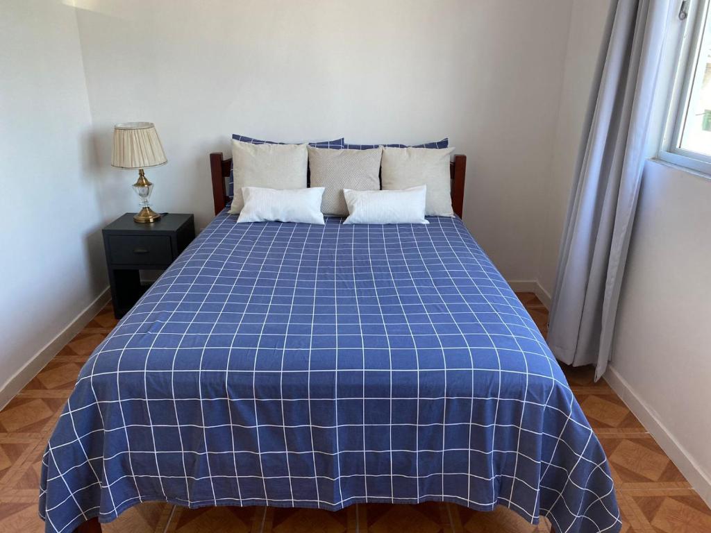 a blue and white bed in a room at Residencial Sullivan - Florianópolis - Loft 01 in Florianópolis