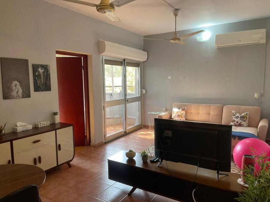 uma sala de estar com um sofá e uma televisão em A cozy one-bedroom in Heron, Djibouti em La Plaine