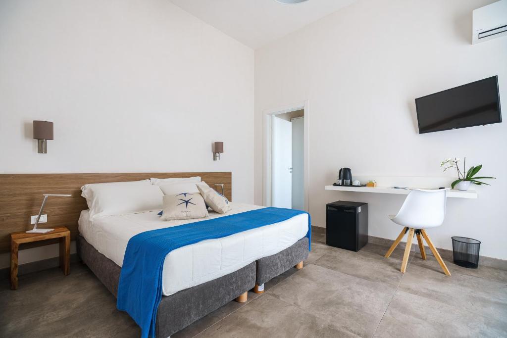 a bedroom with a bed and a tv on the wall at Villa Licari Stagnone in Marsala