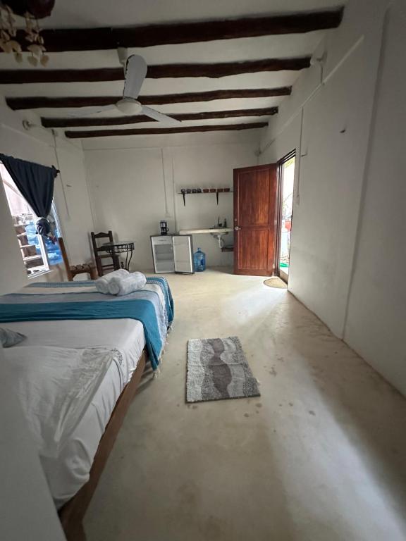 Habitación con 2 camas y alfombra en el suelo en Cuarto chingui en Holbox Island