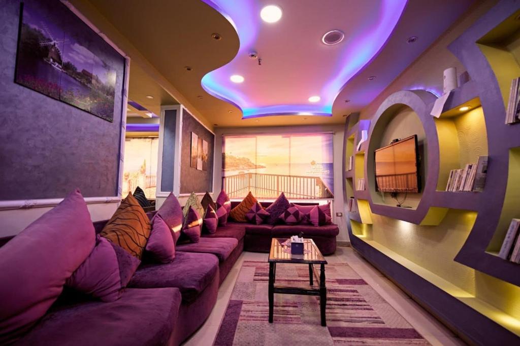 sala de estar con sofá y TV en Abo Elwafa Hotel, en Sūhāj
