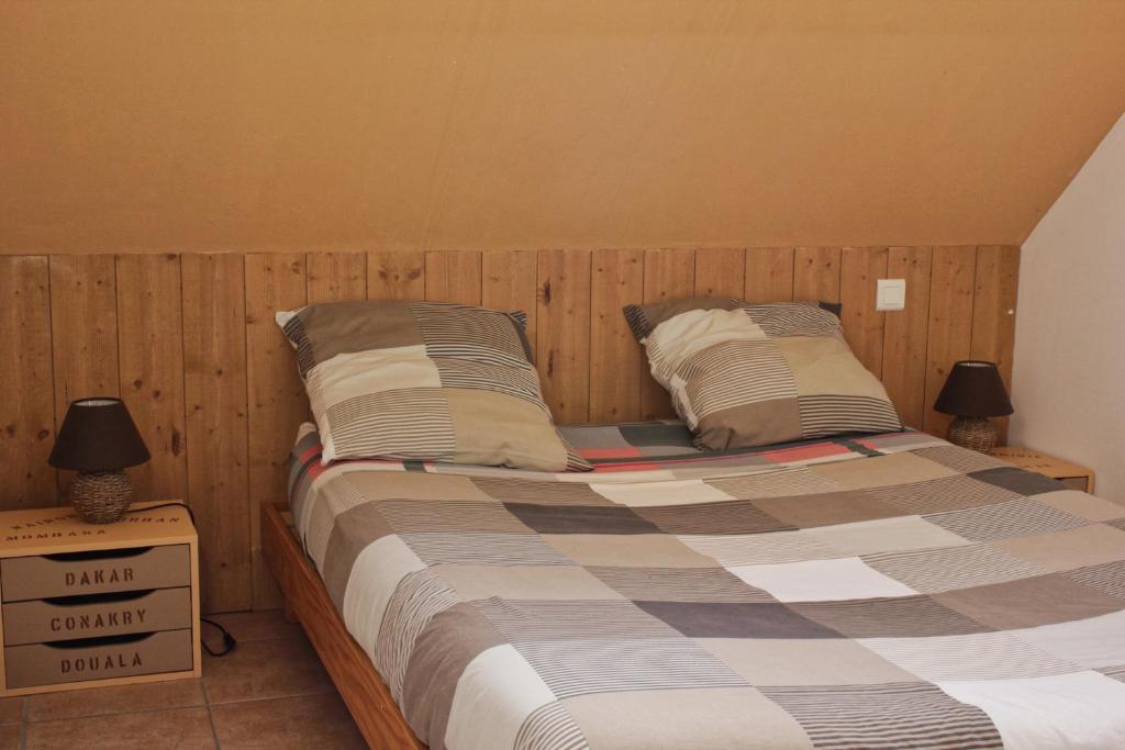 a bedroom with a bed with two pillows on it at Mumbasa - Gîtes du Fozo - Herbignac - La Roche Bernard in Herbignac